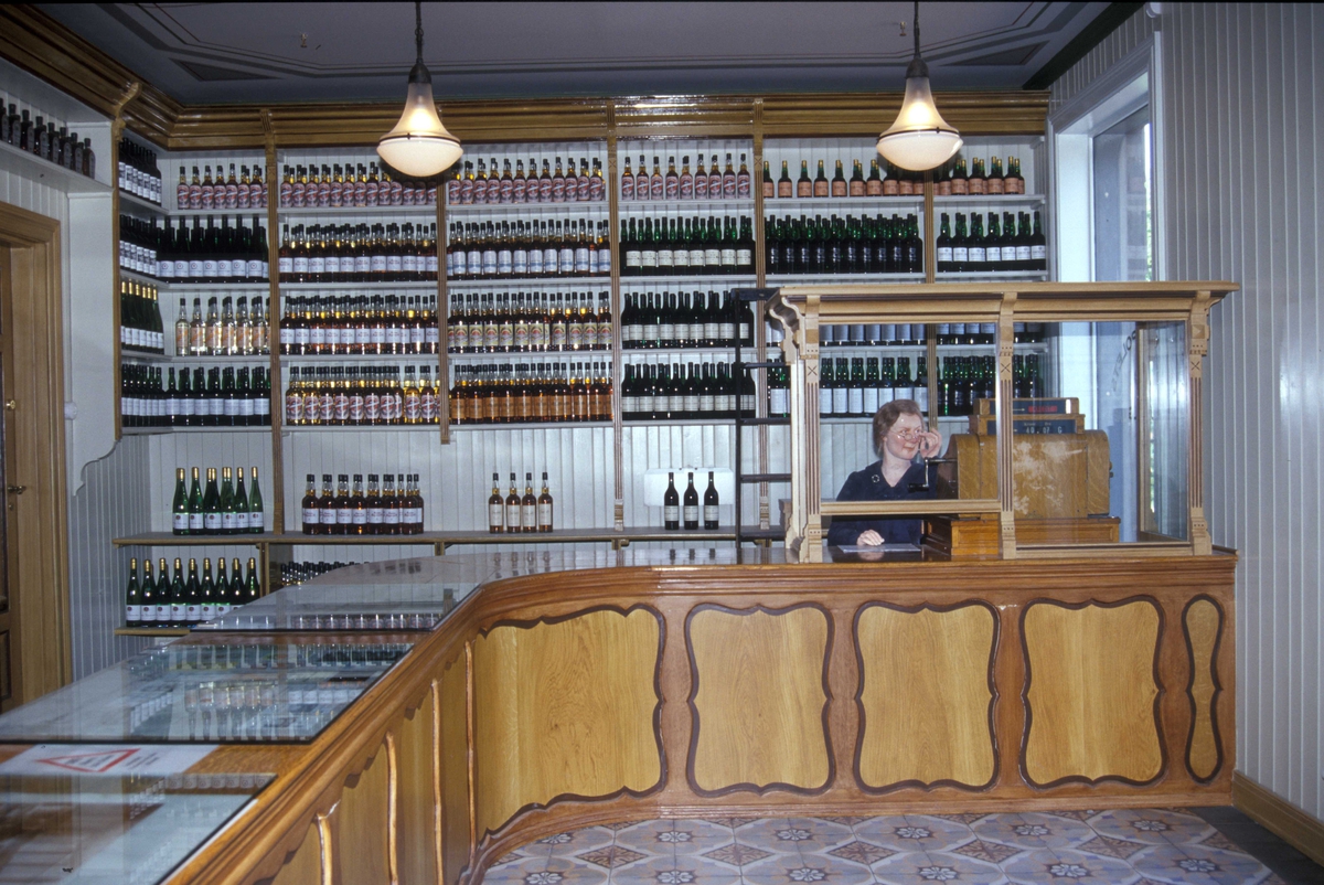 Vinmonopolutsalget, en utstilling  i Wessels gate 15 på Norsk Folkemuseum, bygning nummer 234.Interiør med utstillingsdukke laget av Cecilie Rasch-Halvorsen.