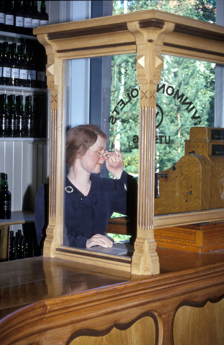 Vinmonopolutsalget, en utstilling  i Wessels gate 15 på Norsk Folkemuseum, bygning nummer 234.Interiør med utstillingsdukke laget av Cecilie Rasch-Halvorsen.