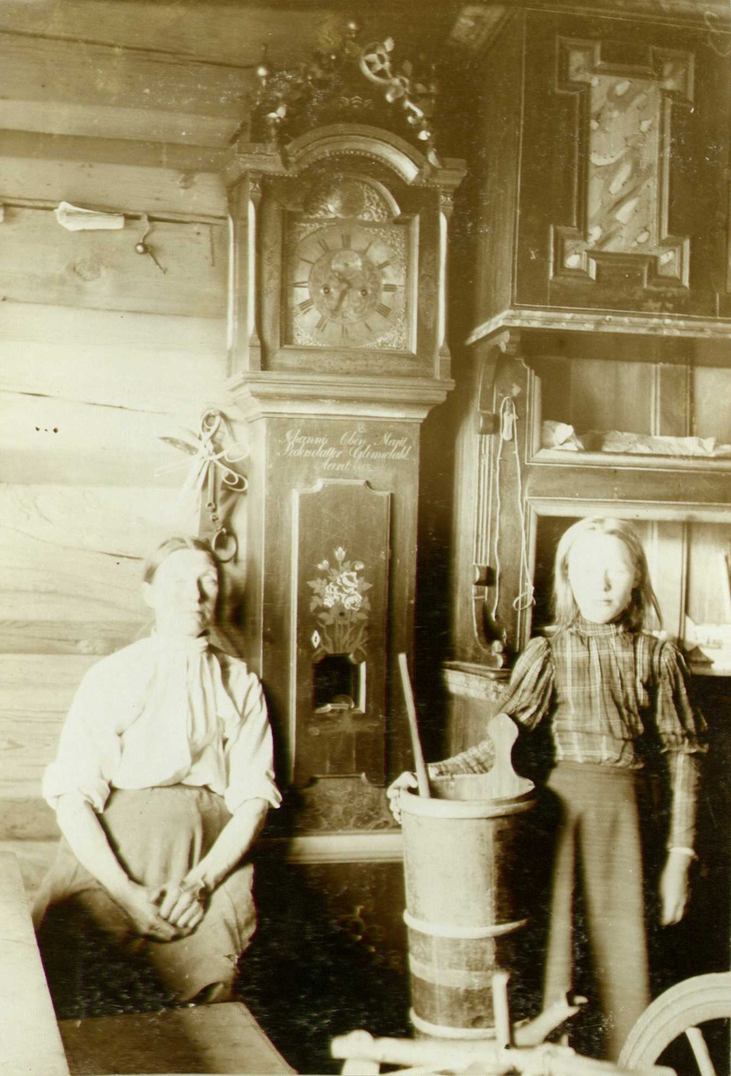 Interiør fra stue, Glimsdal, Lom, Oppland. Kvinne og pike i stuen. Fotografert 1909.