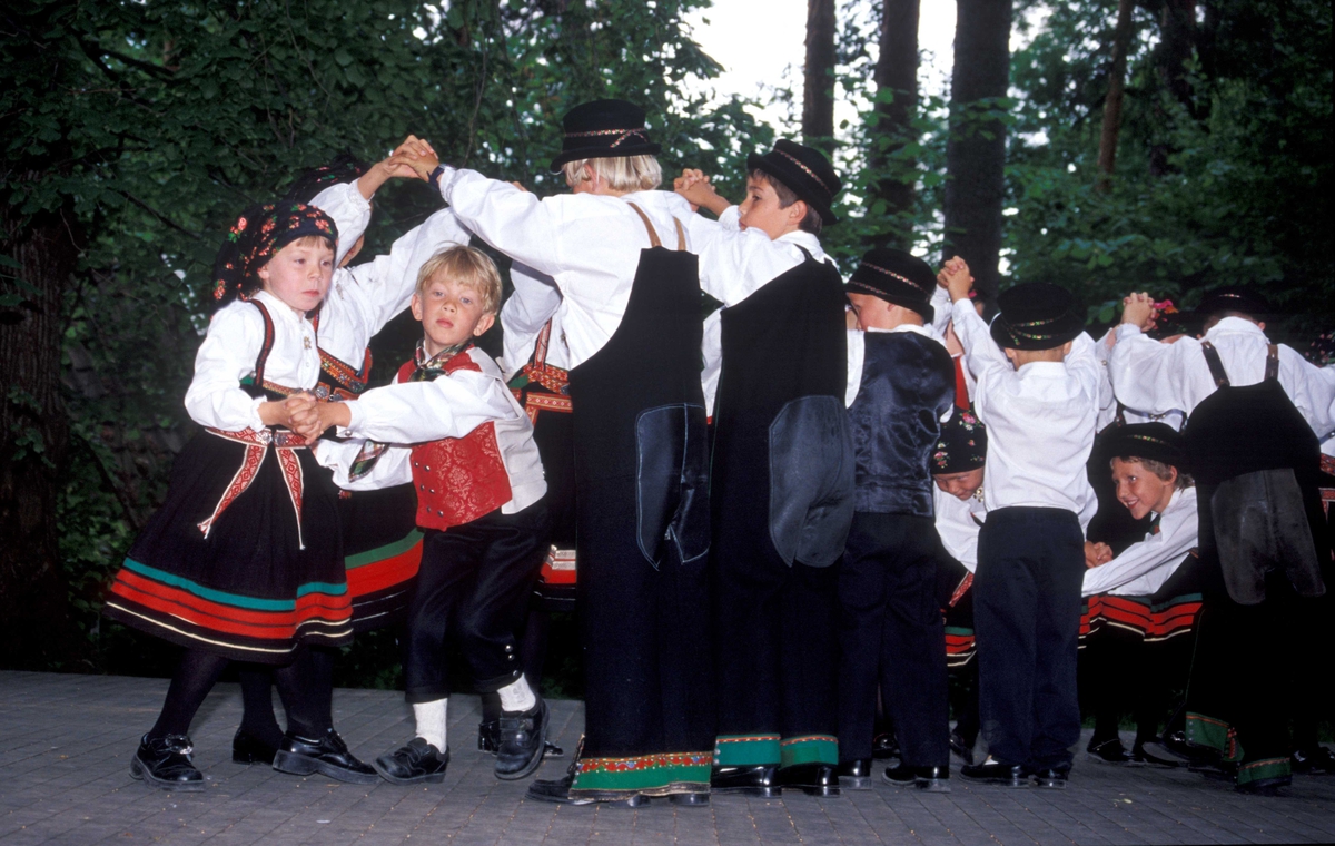 Norsk Folkemuseums dansegruppe, kledd i folkedrakter, danser folkedans i friluftsteateret NF 349.