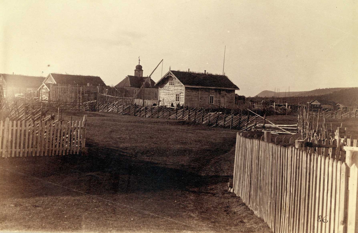 Karasjok, Finnmark. Fotografi fra tettsted med kirke, boliger, gjerder og skigarder.