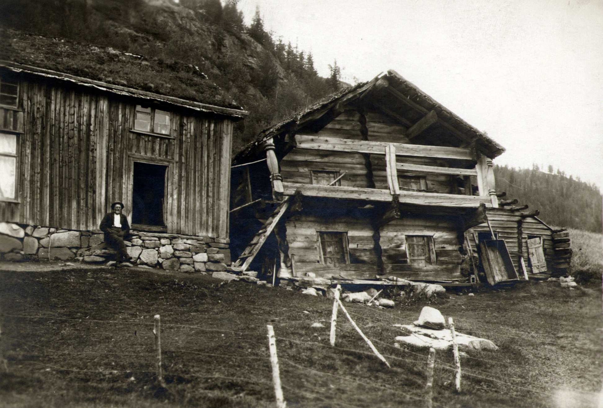 Stue og loft, Tovslid, Fyresdal, Telemark. Mann sittende foran stua.