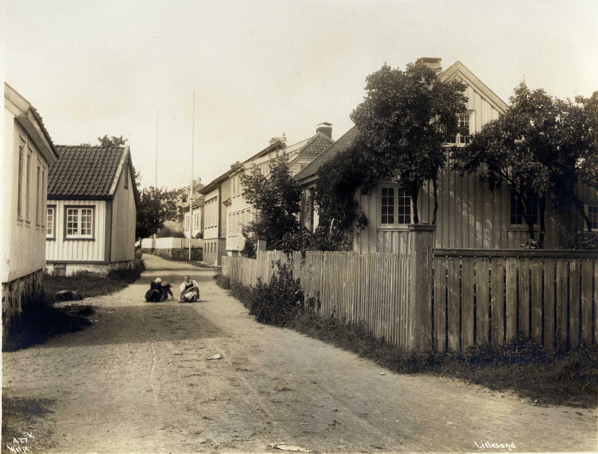 Gateparti med trehusbebyggelse, Lillesand, Aust-Agder. Barn leker i gaten.