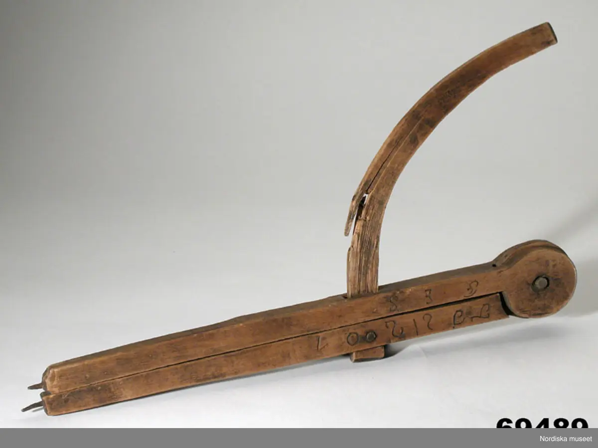 Huvudliggaren:
"Passare fr. Jukkasjärvi sn, Torne lappmark. Från Vittangi. Af trä. Märkt: 'T J S 1801 F E S [alla bokstäver i skrivstil]' Ink. af jägmästaren Hugo Samzelius. 1891. Bil. Samzelius 192."