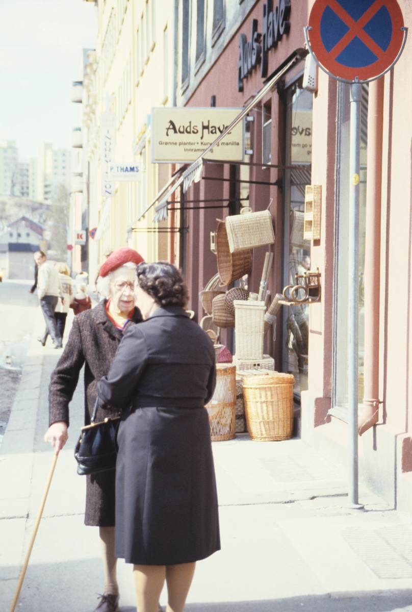 To eldre damer i prat foran butikk som selger kurver. Bildet er antagelig tatt i forbindelse med en artikkel om byfornyelse på Grünerløkka i Oslo. Fotografert for Bonytt 1982.