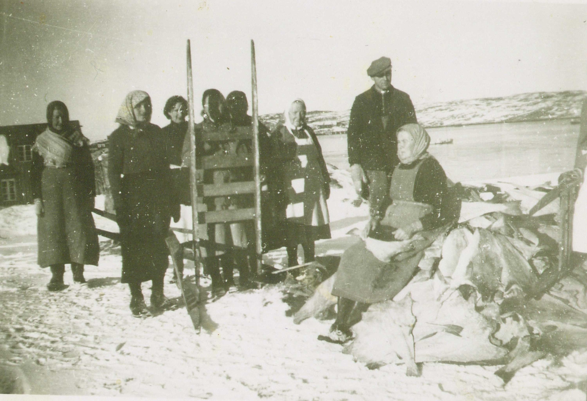 Gruppe klippfiskarbeidere, Dale, Kristiansund, Møre og Romsdal, antakelig 1920-årene. Kvinner og menn med klippfisk og redskaper.