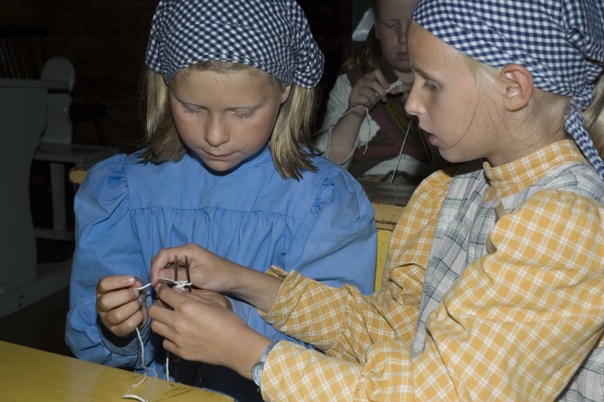 Levendegjøring på museum.
Ferieskolen uke 31 i 2006. Fra skolestua, bygning nummer 196 på Norsk Folkemuseum. To elever med strikketøy.