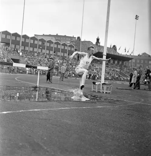 Serie med fotografier fra friidrettsstevne på Bislett i 1955. På noen av bildene løper nr. 57 Ernst Larsen 3000 meter hinder. Jugoslavia-Norge på Bislett.