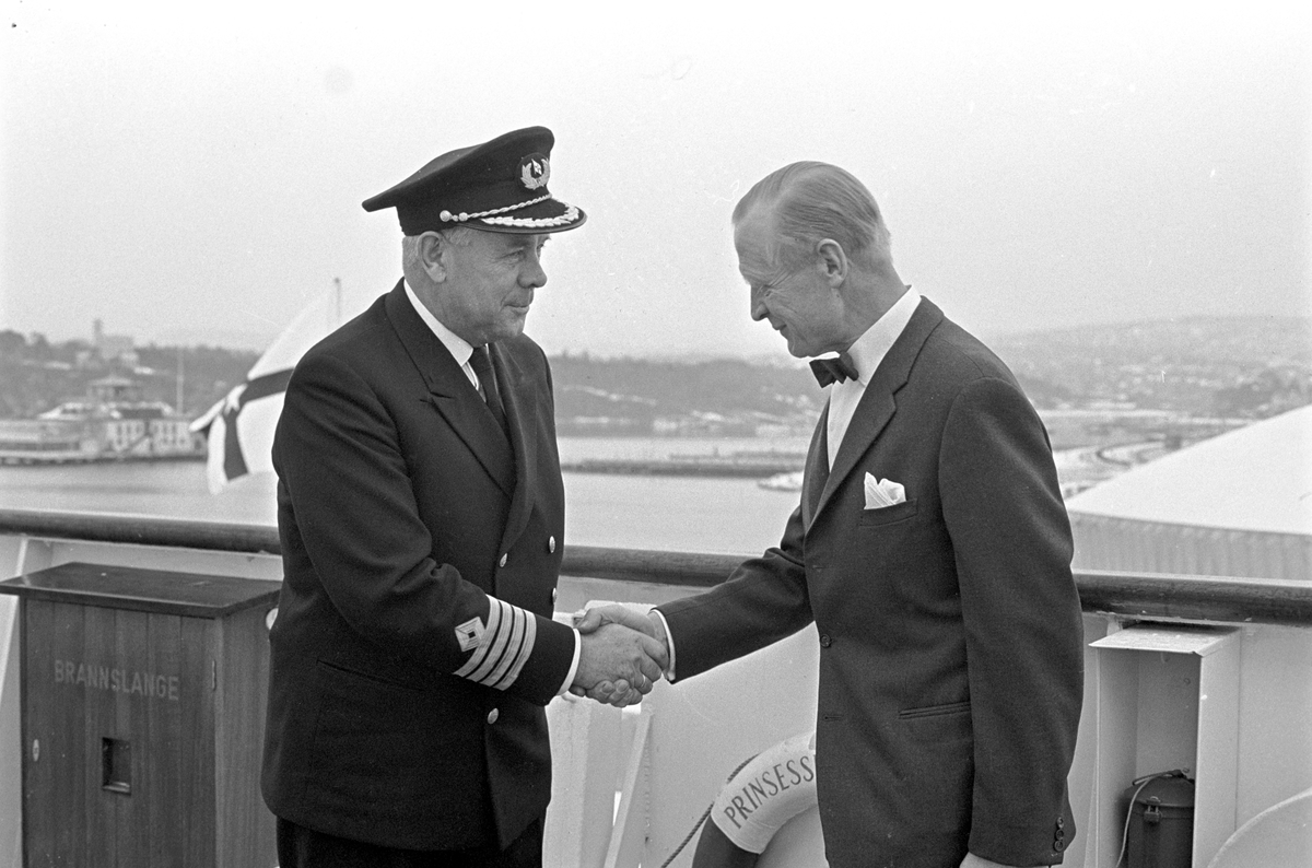 Serie. Fergen "Prinsesse Ragnhild" ligger til kai på Hjortneskaia. To menn hilser på hverandre, den en er ant. kapteinen om bord. Fotografert november 1966.