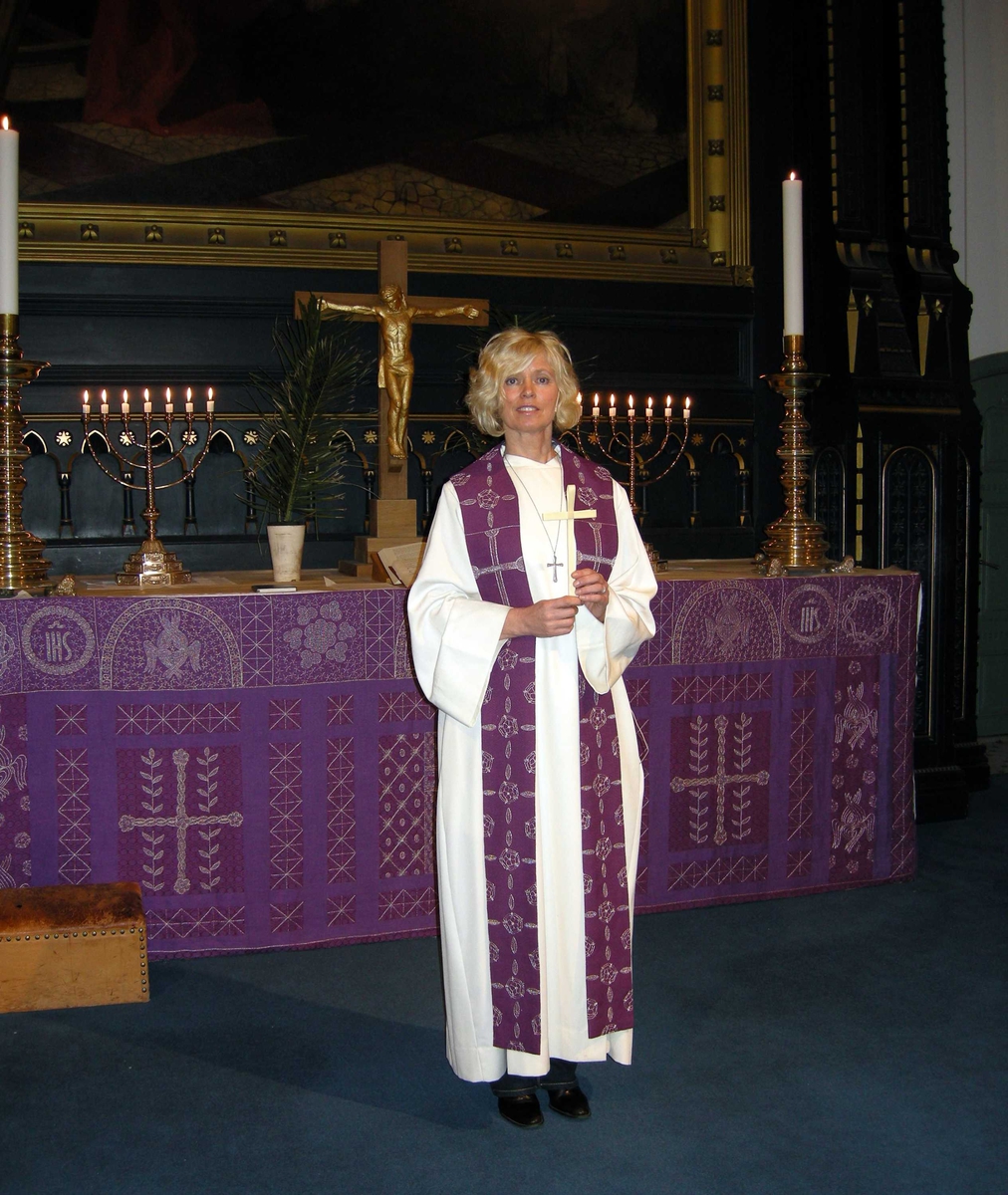 Domkirken i Kristiansand. Palmesøndag, 16.03.2008. Velsigning av palmekors. Serie bilder med kapellan Birte Løvåsen kledd i hvit alba og lilla stola ved koret i kirken. Palmeblader. Kors. Kirketekstilene er utført av Borgny Farstad Svalastog.  