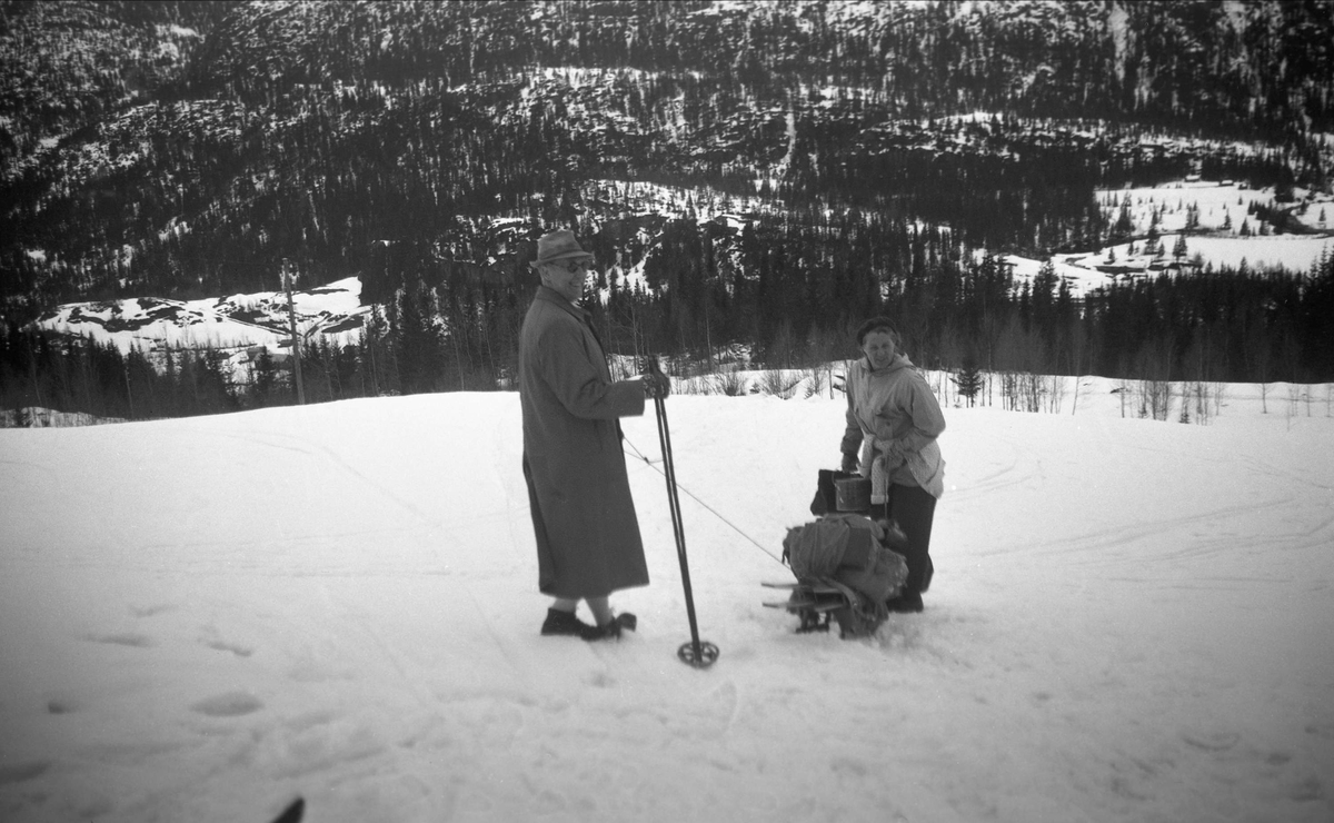 Klara og Sverre Ramstad på vei hjem, med bagasjen på slede, fra påskeferie på Arentz-familiens feriested Ligardshaug. Fotografert 1950.