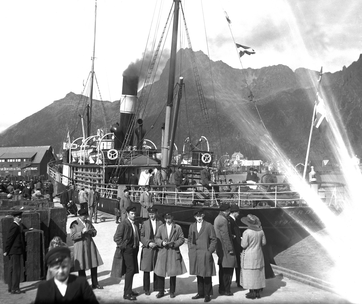 Medlemmer av Trondhjems Studentersangforening på dekk og på bryggen i Svolvær på Nordlandsturnéen. Fotografert 1921.