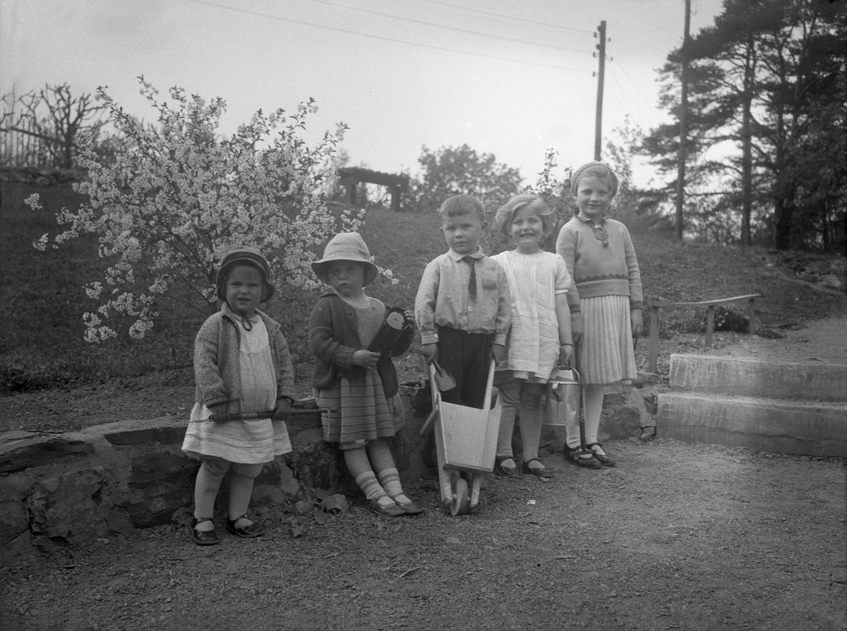 Randi og Fredrik Mørch står sammen med noe andre barn i en hage. Fotografert 1932.