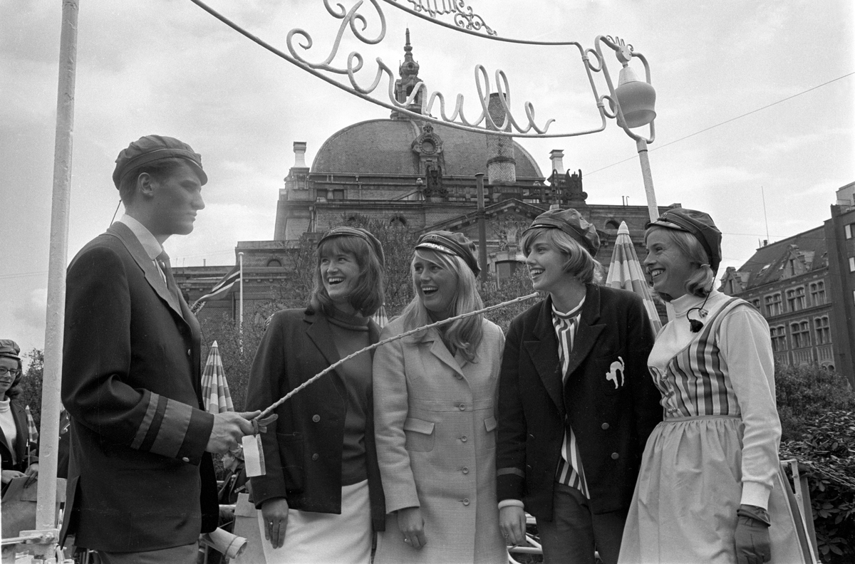 Russen viser russemoter utenfor uterestauranten Pernille i Oslo i mai 1965. Antatt russepresident til venstre og russeprinsesse nummer to fra høyre. Nationaltheatret skimtes i bakgrunnen.