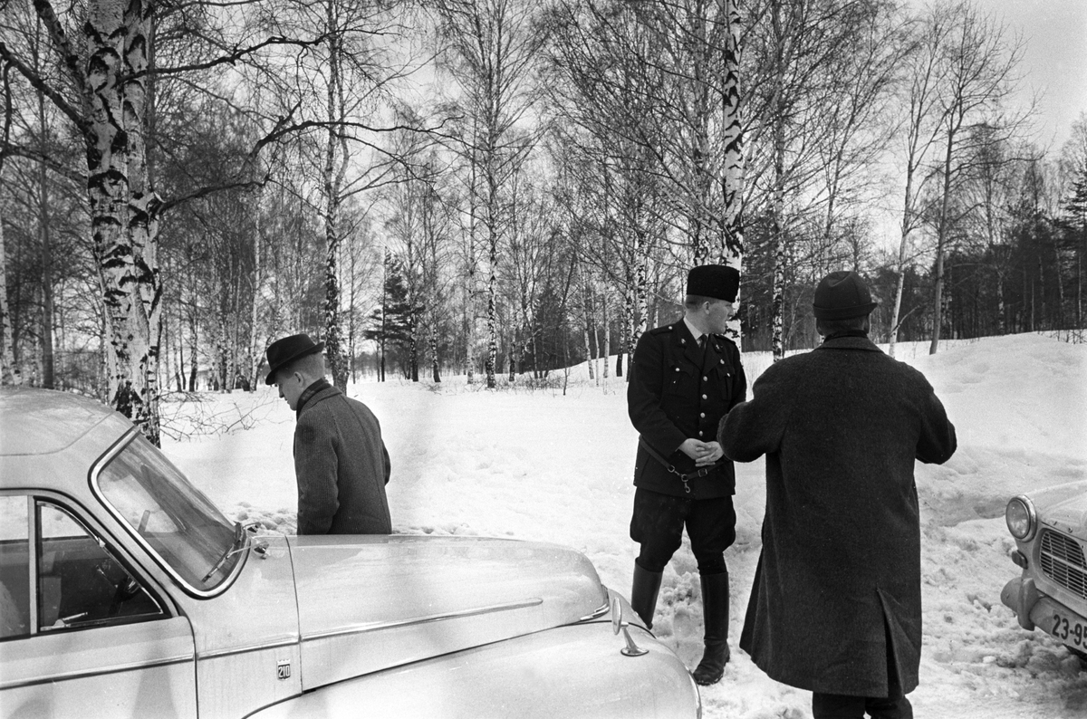 Politietterforskere på åstedsbefaring. Politiet ettersøker en voldsforbryter i skogsområdet rundt Brannfjell i februar 1961. Politibilen er en Volvo Amazon stasjonsvogn.