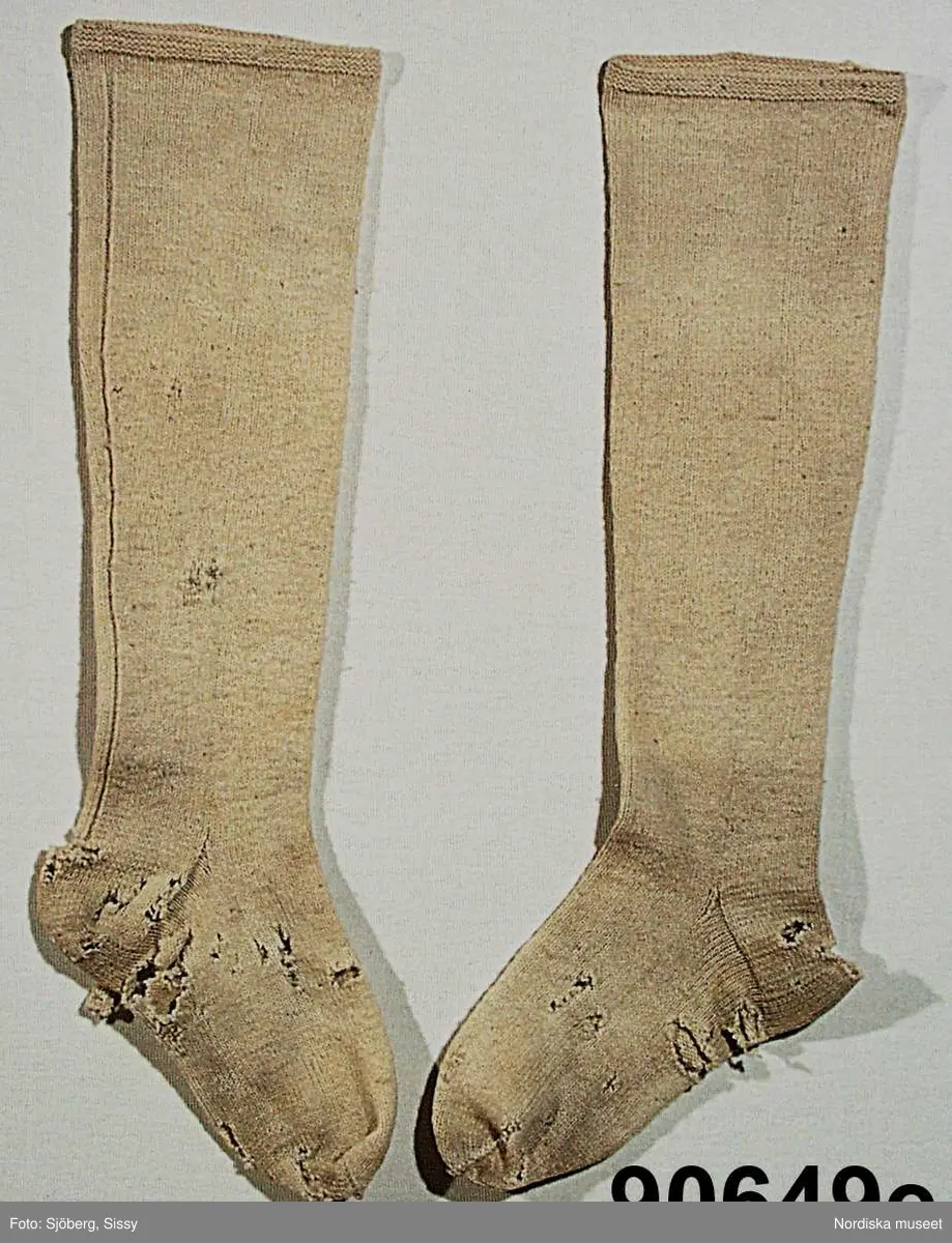 Hel mansdräkt från Österåker A.-F.

A. Hatt
B.Långrock
C.Knäbyxor
D.
E
F. Halsduk

A. Hatt, höjd 15 cm, cylinderformig av svart felb, brättet uppvikt vid sidorna och kantat med svart sidenband. Kullen något insvängd i sidorna. Kring kullen ett svart band med ett rektangulärt spänne på  vänster sida. Svettrem av rött skinn, foder av papper, tryckt med silverfärg.
B. Långrock
C. Knäbyxor längd 79 cm, av sämskat renskinn, midjegjord och smal lucka med 4 kullriga mässingsknappar, 2 fickor vid sidan om luckan. Knäsprund som knäpps med hakar och hyskor, knälinningar som knyts med smala skinnremmar.
/Berit Eldvik juni 2005
F. Halsduk, avklippt tresnibb av yllemuslin. Klippt av ett större halskläde. Grålila bottenfärg med tryckt mönster i rött, grönt och gult på utsparad vit botten, gles lila yllefrans. Fållad med tråckelstygn. Stämpel i svart i ena hörnet, svårläst men troligen: Göteborg 184?.
Viks till smal remsa, vid påtagningen läggs mitten af halsduken över strupen, ändarna tas i kors i nacken, och knyts sedan fram.
/Berit Eldvik 2010-01-08
