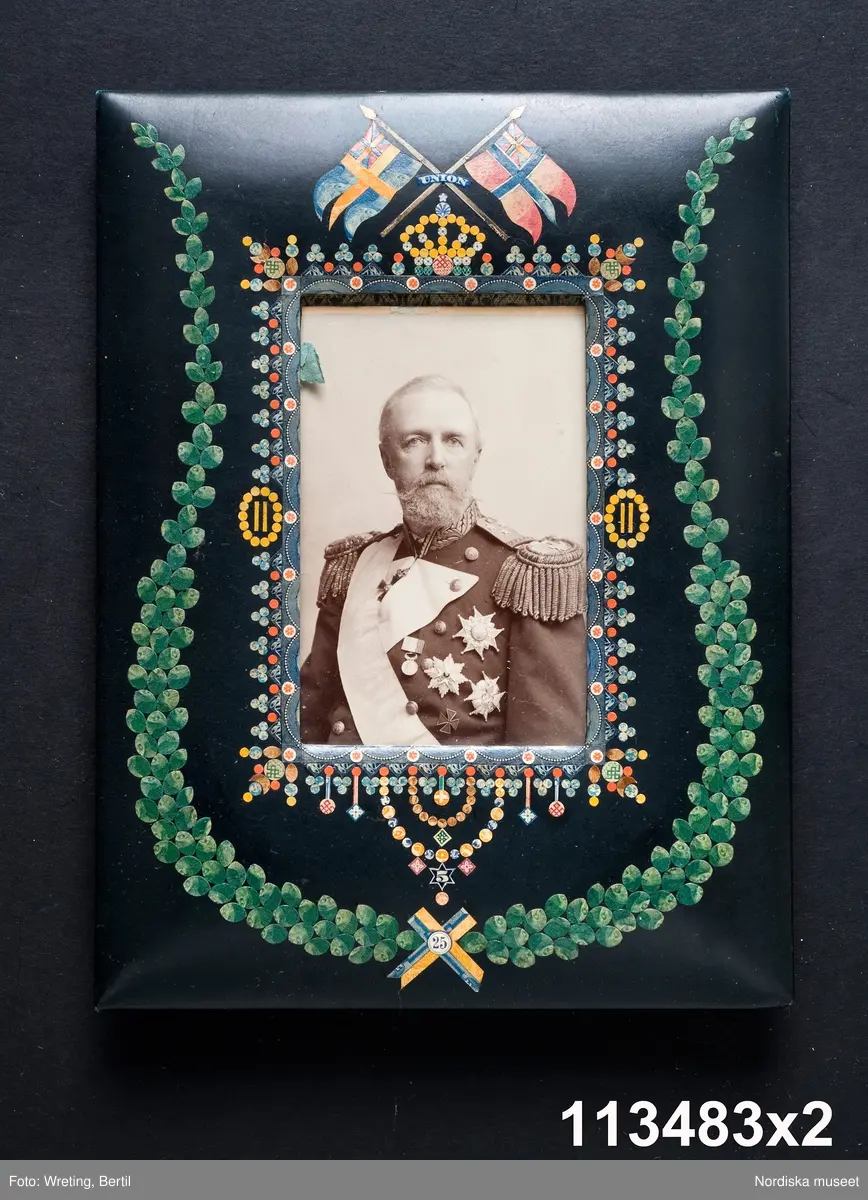 Huvudliggaren:
"a-å
Skrivbordsuppsats, 25 olika pjäser, däribland lampa, ljusstake m.m. allt ornerat med frimärksklipp. Jämte 4 mindre lådor med lösa frimärksdelar. Gåva 17/5 1909 av fru Augusta Cronholm f. Bratt, Birgerjarlsgatan 18, Stockholm."