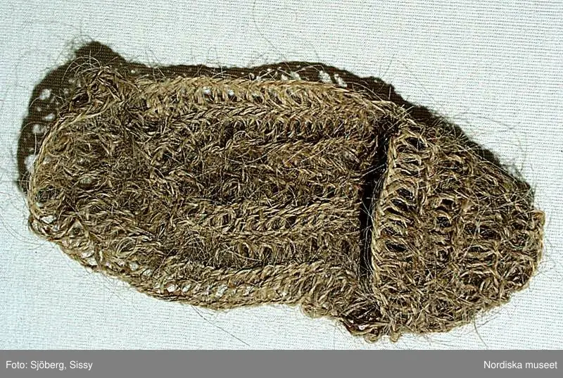 A-B. Tagelsocka för kvinna, ett par.
Nålbindning i stora glesa maskor med spunnet kosvanstagel.
/Berit Eldvik 2002