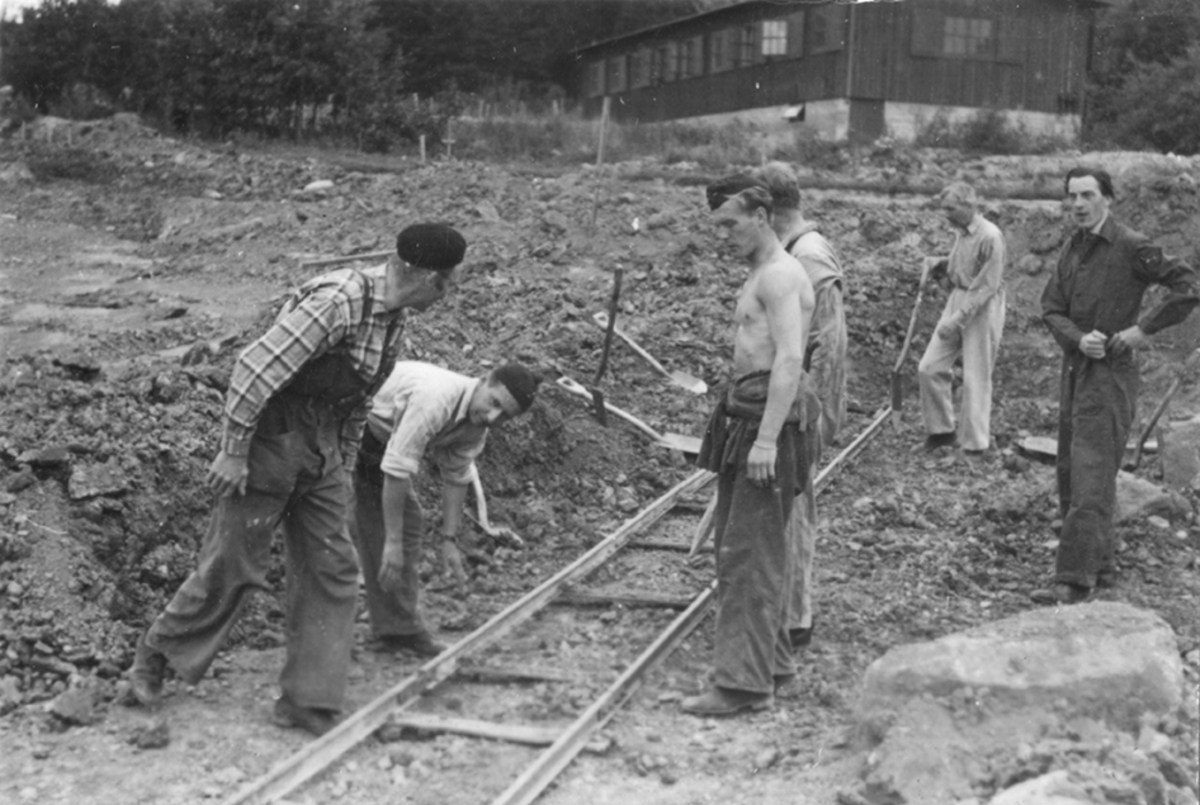 Idrottsplatsen på F 2 Roslagens flygflottilj byggs, 1943. Civilanställda tjänstemän i arbete med grävning.
