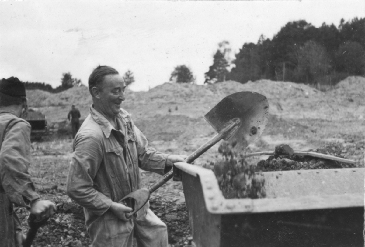 Idrottsplatsen på F 2 Roslagens flygflottilj byggs, 1943. Civilanställda tjänstemän i arbete med grävning.