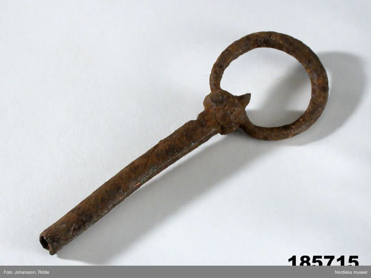 Huvudliggaren:
"Nyckel, 'trollskottbössa', 'nöcklabössa', av järn med spår av koppar, fr. Urshults sn, Kinnevalds hd, Smål. Ink. 30/3 1931 av herr P. M. Magnusson, Dunshult, Urshult."

Bilaga:
Inget utöver huvudliggaren.

En utbredd förklaring till hastigt påkommen sjukdom, såsom värk, frossa, böldutslag, sinnesförvirring eller plötslig död var att den sjuke blivit träffad av ett ont, magiskt skott, ett så kallat trollskott, villarpaskott, lappskott eller finnskott. Trollskott ansågs kunna drabba både människor och djur, dock inte nödvändigtvis med något specifikt uppsåt. Vem som helst som råkade komma i vägen kunde träffas. Inom folkmedicinen behandlades trollskott av 'de kloka' genom så kallad magisk skjutning. Med båge, skutpinnar, bössa eller symboliska skjutvapen av olika slag sköt, eller kastade man med kraft 'skott' mot det onda, antingen i kors över den sjuke, under eller över denne, ofta i kombination med magisk läsning. Se vidare Tillhagen C-H., (1962). 
/Ulrika Torell 2007-12-28