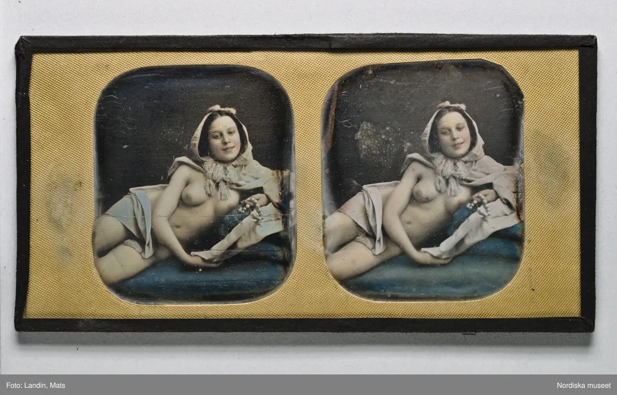 Dagerrotyp / daguerreotyp, handkolorerad stereoskopbild. Föreställer ung lättklädd kvinna, liggande på sidan.
På bakstycket påklistrad papperslapp med bläckskrift: 'Tillhör /F. Scheele/ Sibyllegatan 38' (överstruket m. blyerts). Med blyerts längre ned: "Daguerrotyp av Bergström Sthlm."
Nordiska museet inv.nr 205466
-
Reclining semi-nude. Ninth-plate tinted stereo daguerreotype w/ brass mat.