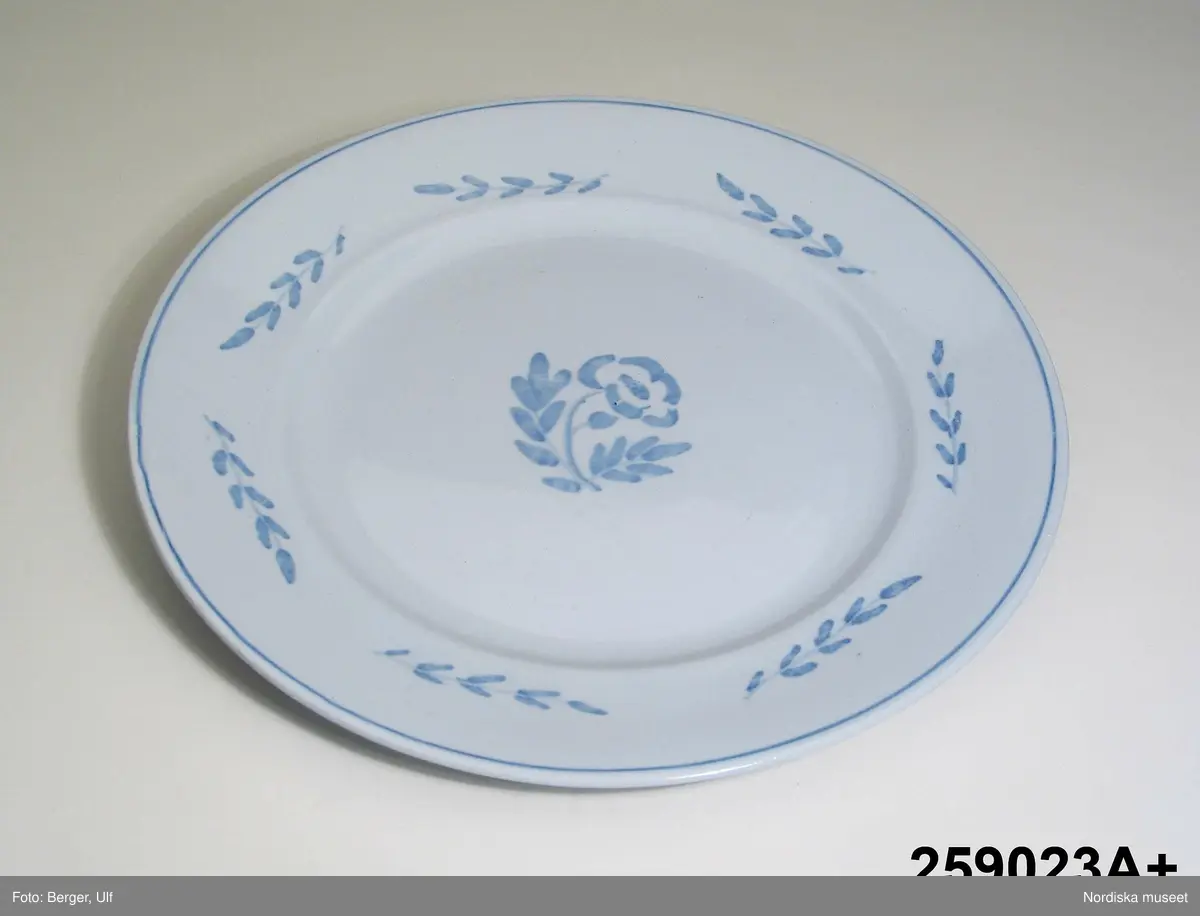 Huvudliggaren (år 1959):
"259023a-m Servis, flintporslin, modell 'Blå ros'; ljusblå glasyr med dekor i mörkare blått, blommor och kvistar; tallrikar, fat, karott, saladier, tillbringare, kaffekoppar. Wilhelm Kåge Gustavsberg 1917. Utställd på Hemutställn. i Stockholm 1917. G. 22/12 1959 [av] Arkitekt Robert Berghagen."

Utdrag ur bilaga:
"Matservis Blå Ros. komp. av Wilhelm Kåge Gustavsberg Utställd Hemutställningen 1917. 1 Bringare Sign. Original W.K., 1 Karott, 2 små fat, 1 salladier med grepp, 1 salladier fyrsidig, 1 saltkar, 2 satser Kaffekopp och fat, 2 satser av fyra tallrikar, 2 satser av två assietter. [Därutöver en tidigare mindre detaljerad lista med något färre delar av servisen Blå ros.]"