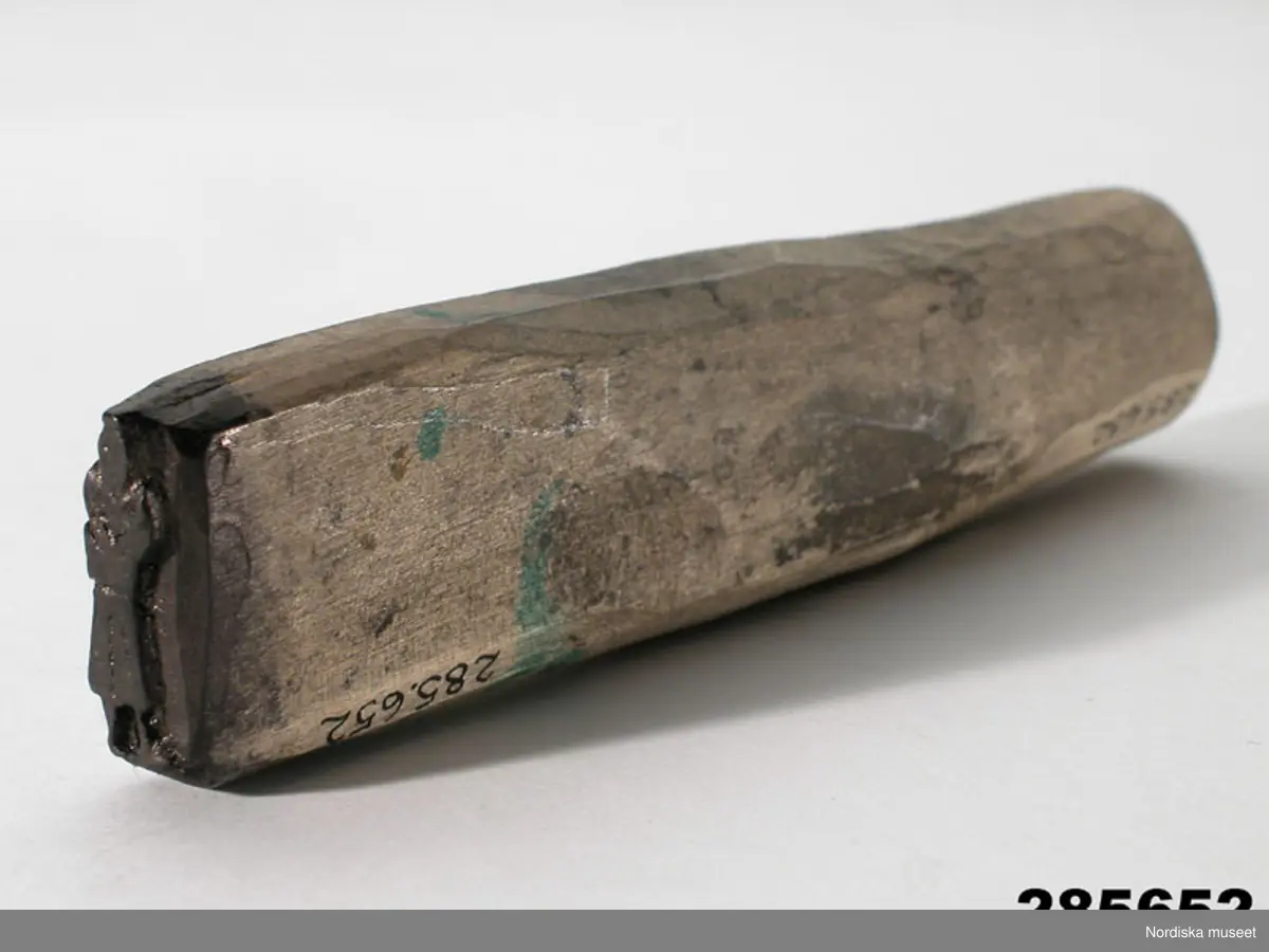 Huvudliggaren:
"Stämpel av björk; utskuren same i ena änden, den andra slät. L ca 13,5 cm, Br ca 3,5 cm. Funnen 15/8 1972 i magasin, ur Johan Turis kvarlåtenskap, anv. vid framst. av bilder ur lapparnas liv; jfr 228.777 - 228.800. G[åva av] Okänd. [Brukningsort:] Lappland Jukkasjärvi sn Talma lappby."