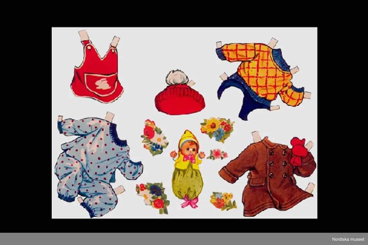 Inventering Sesam 1996-1999:
Kuvert L 24,9 cm, H 20 cm
Kläder och leksaker L 3,2 - 19 cm
Samling pappersdockskläder och leksaker (dockan saknas) i kuvert.
Kuvert; brunt papper med tryckt text "INSTITUTET FÖR Högre Reklamutbildning / Mäster Samuelsgatan 44 . Stockholm C" och handskrivet i rött och blått (spretig stil, trol. skrivet av Cornelia själv) "CORNELIA".
Innehåll 11 kläder, 27 leksaker/diverse (enligt äldre kat.kort 30 st).
- Vit babysäng på hjul. - Brun rock, röd vante. - Brun keps.- Gul och röd tröja blå byxor. - Blå kortärmad tröja, gula långbyxor. - Rödprickig pyjamas - Grön kofta med byxor - Röd haklapp, med kanin. - Rött förkläde. - Röd mössa med vit tofs - Röd halsduk. - Röd hätta.
Brun nalle - Segelbåt - Tåg - Clowndocka - Bok - Babydocka med napp - Hink med spade - Boll - Gult flygplan - Svart bil - Skallra med röd rosett - Två klotsar - Fyra klotsar -  kakformar - Elefant på hjul - Röd boll - Gul sked - Rosa sax - Munspel - Tvättfat med svamp - glass - Tallrik - 5 st olika blombuketter.
Har tillhört Cornelia Lindberg (född 4/11 1953) som använde föremålet när hon var på besök hos sin farmor (givaren) på Artellerigatan 74 i Stockholm. Hon bodde annars hos sin frånskilda och omgifta mor i New Mexico, Mexico.
Har förvarats i "Cornelias kartong" (inv.nr. 298.077) där hon förvarade sina mindre leksaker och intressanta saker (inv.nr. 298.078-298.107). Kartongen brukade stå på "Falses spegel"
i sängkammaren hemma hos farmor (givaren). "False"= Charles Boklund, givarens far, Cornelias farmors far, var stadsvetrinär i Helsingborg. När han dog flyttades hans möbler till givarens våning i Stockholm, där spegeln ställdes i sängkammaren.
Leif Wallin sept 1997