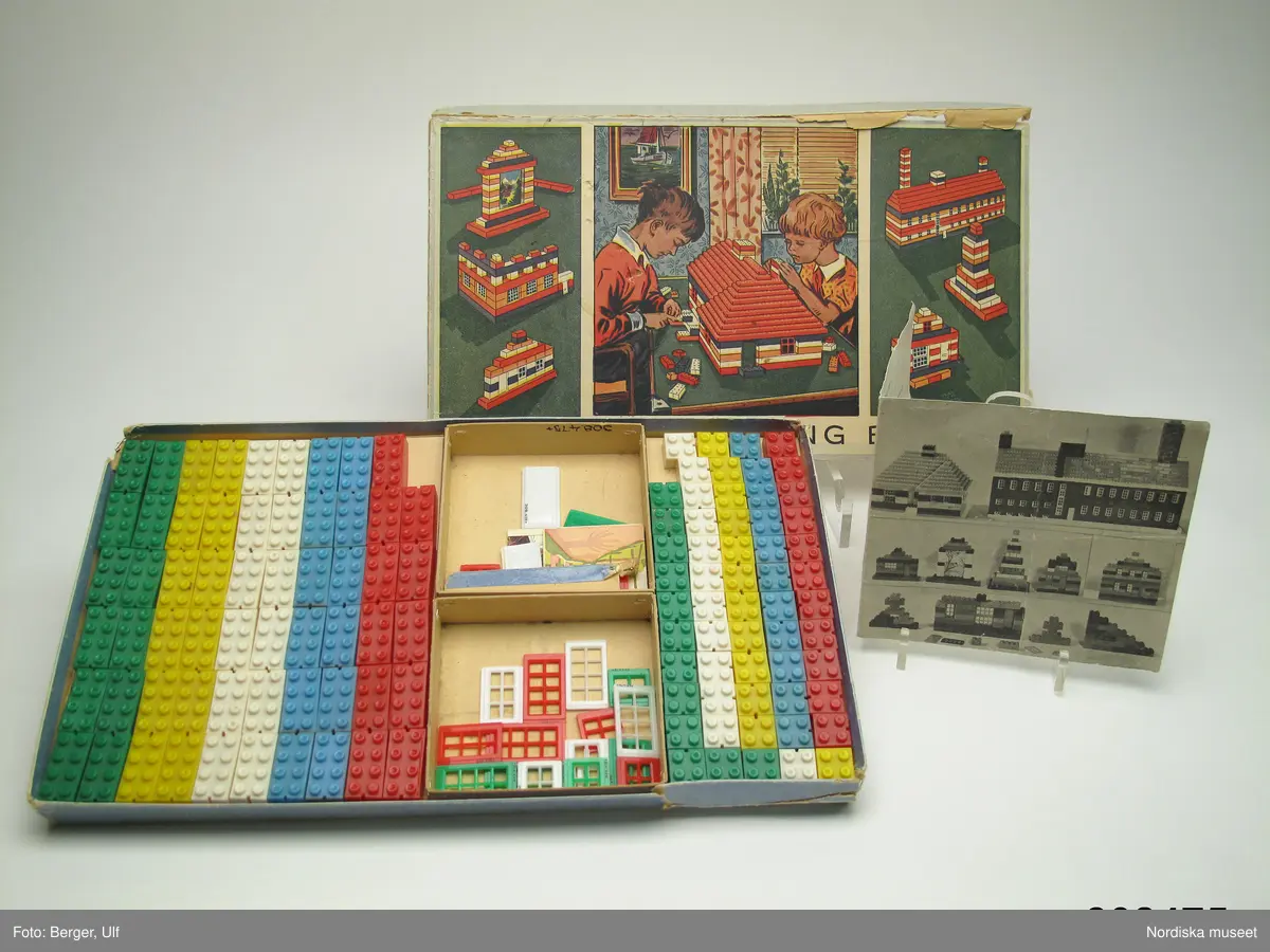 Enligt katalogkort:
Originalförpackning med Automatic Binding Bricks, med 59 hela och 60 halva byggbitar av plast i färgerna grönt, vitt, gult, blått och rött. 6 fönster med med 8 rutor, 6 fönster med 6 rutor, 6 fönster med 4 rutor, 4 dörrar, 2 motiv tryckta på kartong (landskap samt caféinteriör). 

Medföljande bruksanvisning tryckt 1950 i Värnamo.