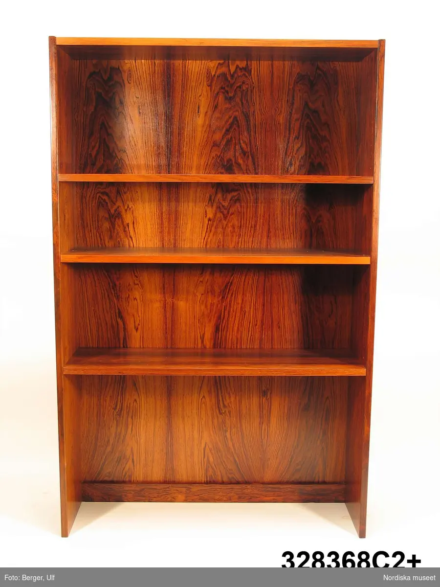 a-e:
Bokhylla, "Excellent",  med TV-bänk samt bar- och vitrinskåp, jakarandafaner på spånskiva, IKEA, 1968. 

Hyllan består av fyra sektioner med hyllor löst placerade på underredet. Skåp- och byråunderdelar med ryggar av masonit, fastnitade. Kvadratiska ben, fastskruvade i underredet. Lådsidor m.m. av björk och lådbottnar av vitlackerad masonit. Flyttbara hyllplan. Draghandtag och gångjärn av mässing.  Enligt IKEA-katalogen 1968 är ytan plastbehandlad.

Hyllan uppställd, från vänster till höger:
a:1+) Skåp med två dörrar samt a:2+) hyllöverdel, ett fast och två flyttbara hyllplan. Överst vitrindel med två skjutdörrar av glas (höjd 53,5 cm, bredd 41,5 cm).
b:1+) Byrå med tre lådor samt b:2+) hyllöverdel med tre flyttbara hyllplan. 
c:1+) Tv-bänk med en låda samt c:2+) hyllöverdel med tre flyttbara hyllplan.
d:1+) Skåp med två dörrar samt d:2+) hyllöverdel med 1 flyttbart hyllplan. Överst vitrindel med två skjutdörrar av glas (höjd 53,5 cm, bredd 41,5 cm), därunder ett barskåp med spegel som bakvägg, utrymme för flaskor till vänster och två glashyllor (48 x 19,5 cm) till höger. Barskåpet med fällbar klaff med lås. Belysning monterad i skåpets överkant.
e) Nyckel till barskåpets klaff. L 4,3 cm.

Möbeln har använts av givarinnan, Berith Helldén, f. 1945, hemmafru, och hennes man, Lars-Göran Helldén, f. 1946, inköpare, Tungelsta. Paret gifte sig 1967 och bodde som nygifta i en liten lägenhet i Borås. När de fick möjlighet att flytta till en större lägenhet i samma stad, utökades vardagsrumsmöblemanget. Hyllan inköptes 1968 på IKEA i Älmhult. Enligt IKEA-katalogen 1968 kostade de fyra hyllsektionerna totalt 2484 kronor. Hyllan har använts som förvaringsmöbel i vardagsrummet i Borås och i familjens nuvarande bostad i Tungelsta fram till våren 2005, då den inköptes av museet.

Hyllans innehåll har dokumenterats och en utförlig intervju med Berith Helldén har gjorts 2005-05-09 (se arkivreferens).
/Anna Womack 2005-10-18
