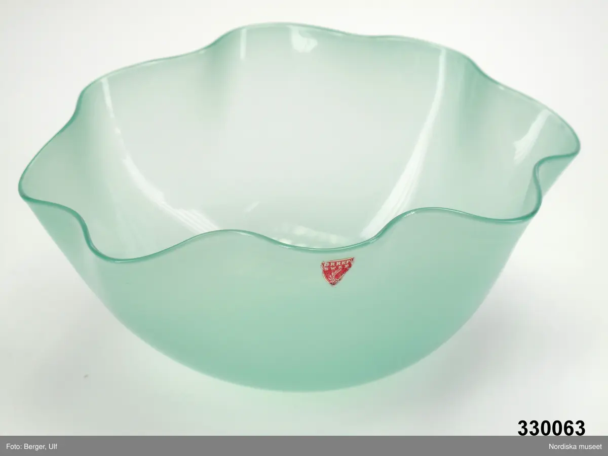 Glasskål, modell Kantara, formgiven av Sven Palmqvist, 1944, för Orrefors. Ljusgrönt glas, oval form med veckade kanter och välvd botten. Skålen är blåst på fri hand, placerad upp och ned över en träkubbe för att få den välvda formen, den veckade kanten formades med hjälp av träpinnar som långsamt drogs över kanten. Kantara skålen tillverkades i fem olika modeller.
/Cecilia Wallquist 2010-04-07