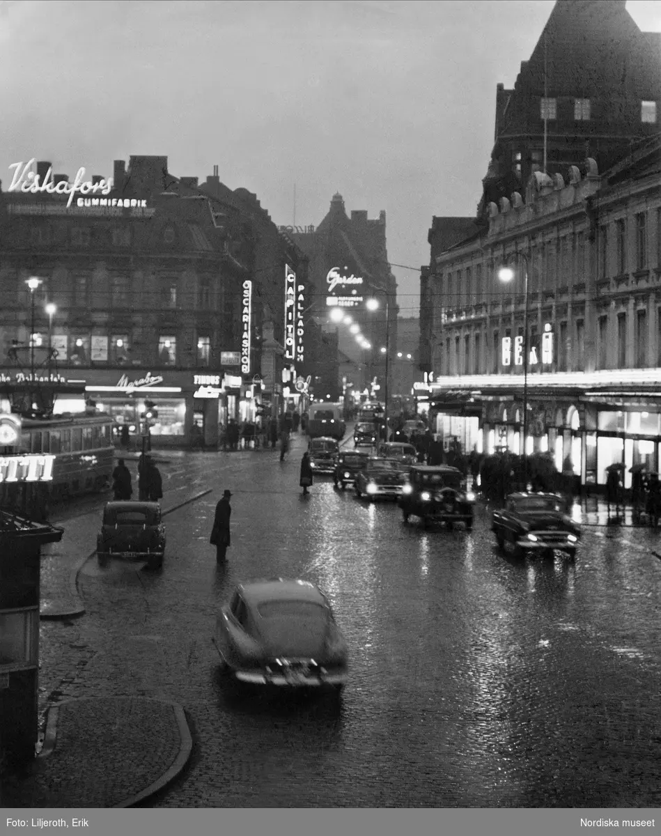 Regn, skymning, trafik och neonskyltar på Södergatan, Malmö.