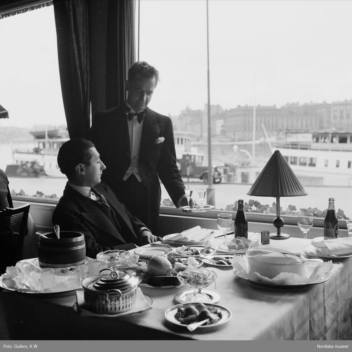 Kypare serverar Bernard Valéry snaps på Grand Hotels veranda, Stockholm. "En fransman ser på Stockholm".