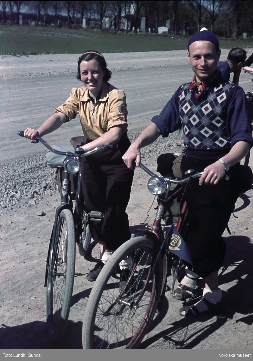 Semester, fritid. Par på cykelutflykt tar paus längs grusväg, pingstfärd till Mellingeholm i Roslagen.