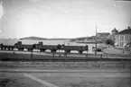 Strömstad från Järvägsslätten. Godsvagnar i förgrunden, kallbadhuset i fonden.