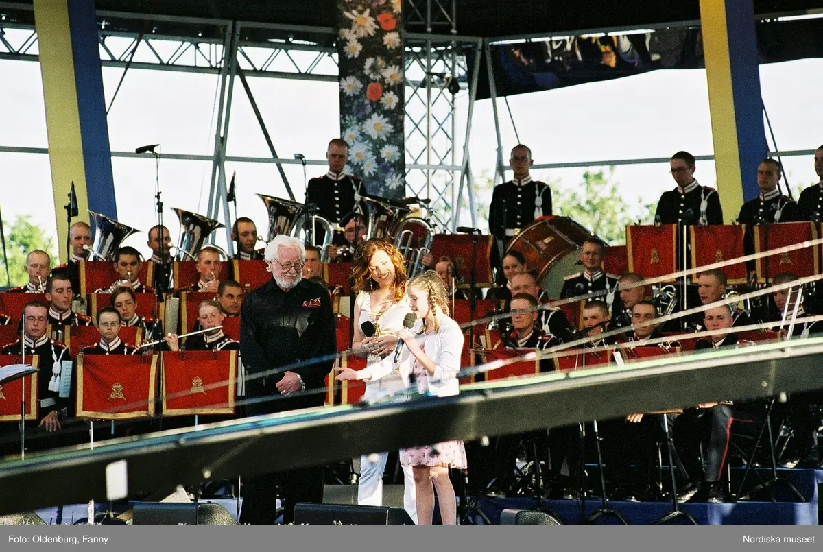 Firandet av den svenska nationaldagen den 6 juni 2004 på Skansen, Stockholm. Den kungliga familjen. Orkester. Publik. Artisterna Jan Malmsjö, Shirley Clamp, Magnus Carlsson.