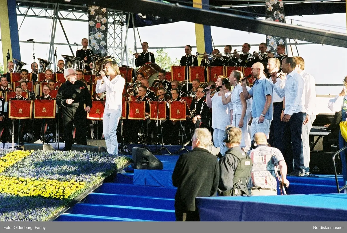 Firandet av den svenska nationaldagen den 6 juni 2004 på Skansen, Stockholm. Den kungliga familjen. Orkester. Publik. Artisterna Jan Malmsjö, Shirley Clamp, Magnus Carlsson.