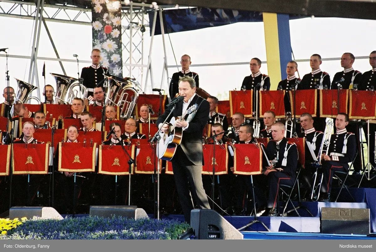 Firandet av den svenska nationaldagen den 6 juni 2004 på Skansen, Stockholm. Den kungliga familjen. Orkester. Publik. Artisterna Shirley Clamp, Tomas Ledin och Lasse Berghagen. Programledaren Agneta Bolme Börjefors.