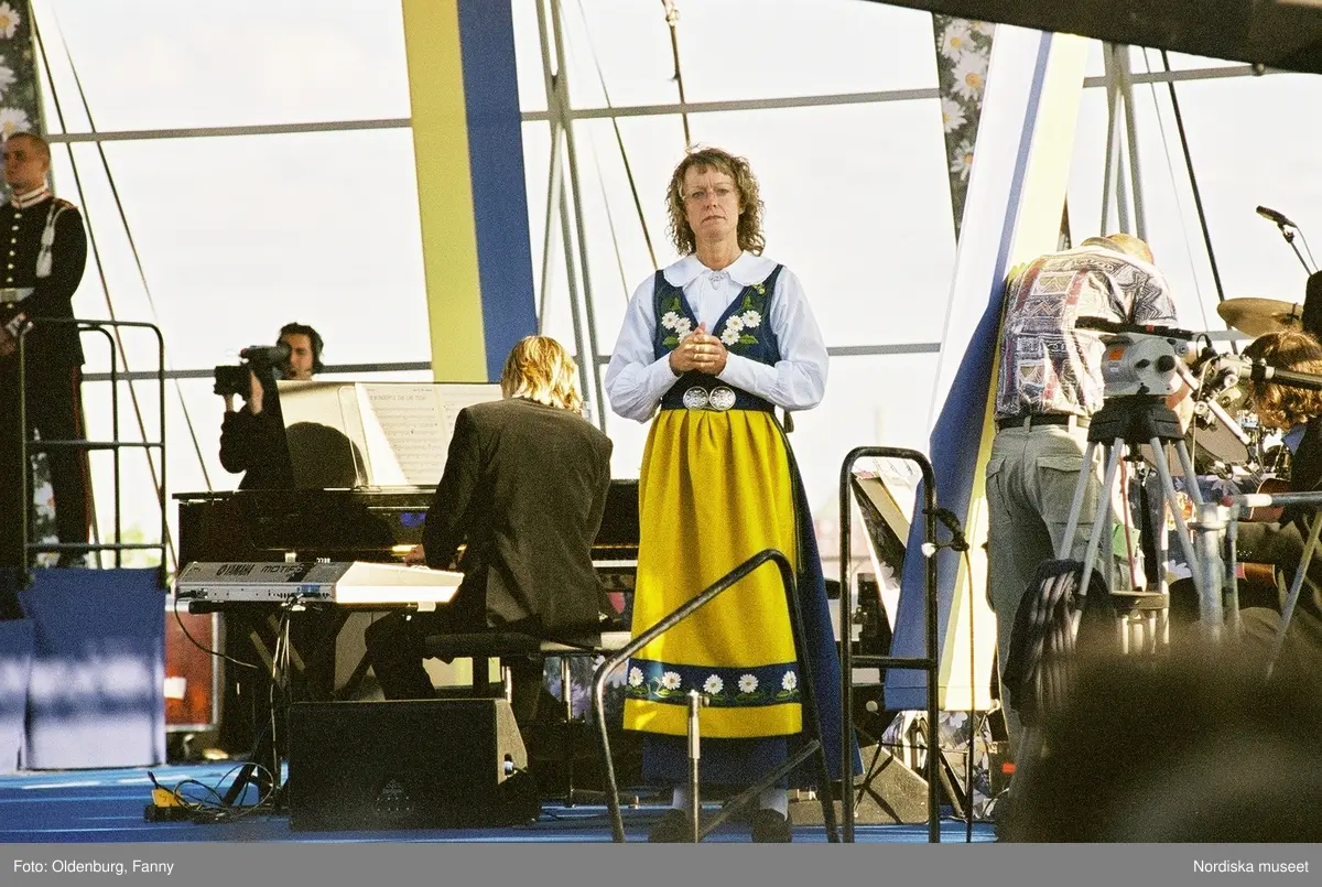 Firandet av den svenska nationaldagen den 6 juni 2004 på Skansen, Stockholm. Den kungliga familjen. Orkester. Publik. Artisterna Shirley Clamp, Tomas Ledin och Lasse Berghagen. Programledaren Agneta Bolme Börjefors.