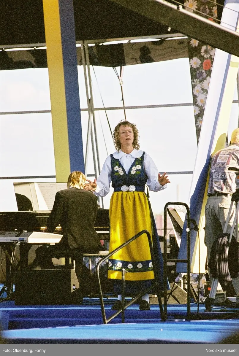 Firandet av den svenska nationaldagen den 6 juni 2004 på Skansen, Stockholm. Den kungliga familjen. Orkester. Publik. Artisterna Shirley Clamp, Tomas Ledin och Lasse Berghagen. Programledaren Agneta Bolme Börjefors.