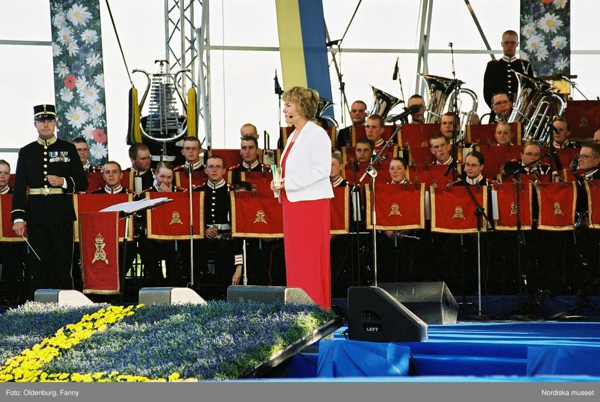 Firandet av den svenska nationaldagen den 6 juni 2004 på Skansen, Stockholm. Den kungliga familjen. Orkester. Publik. Artisterna Shirley Clamp, Tomas Ledin och Lasse Berghagen. Programledaren Agneta Bolme Börjefors.