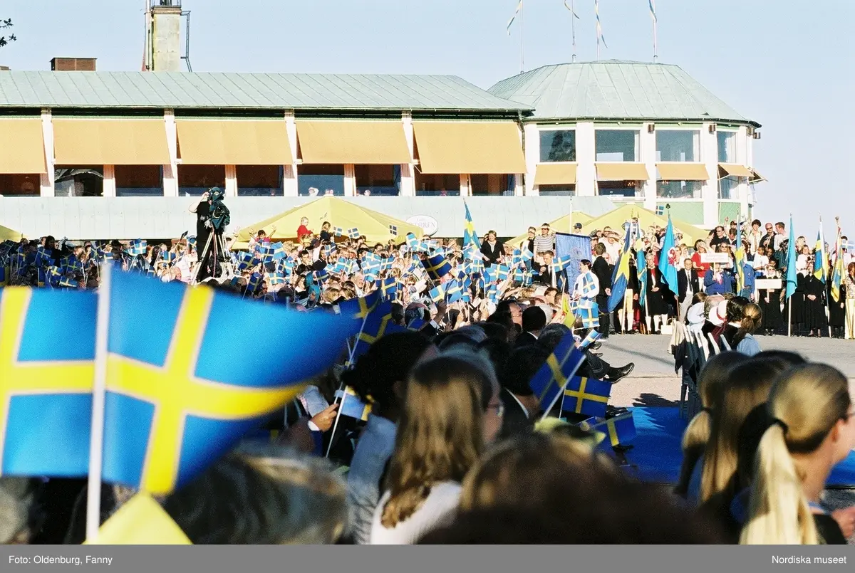 Firandet av den svenska nationaldagen den 6 juni 2004 på Skansen, Stockholm. Den kungliga familjen. Orkester. Publik. Artisterna Shirley Clamp, Tomas Ledin och Lasse Berghagen. Programledaren Agneta Bolme Börjefors.