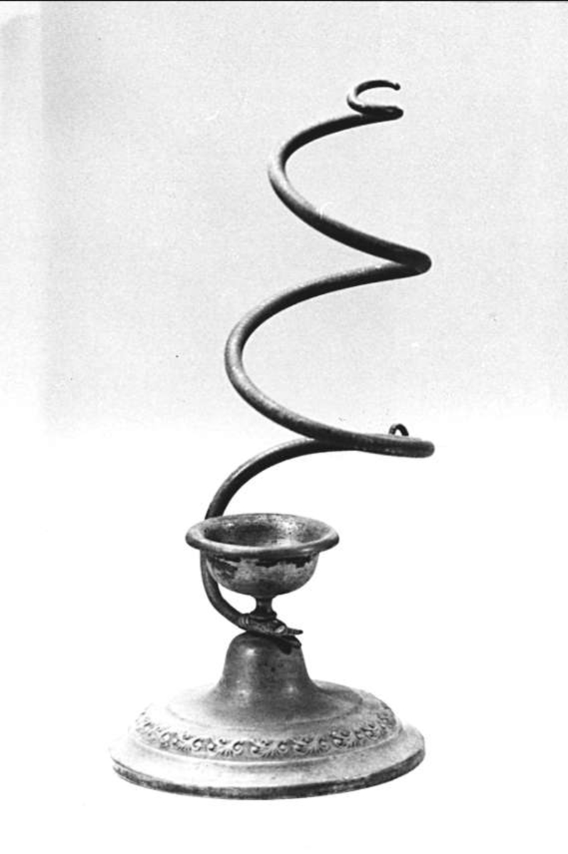 Vaxstapelljusstake med fot av mässing med dekorrand i relief, ormformad spiral av mässing.
 
