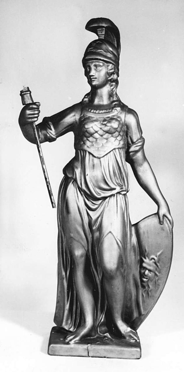 Staty föreställande Pallas Athena av förgylld gips.
Har stått på piedestal UM4247b.