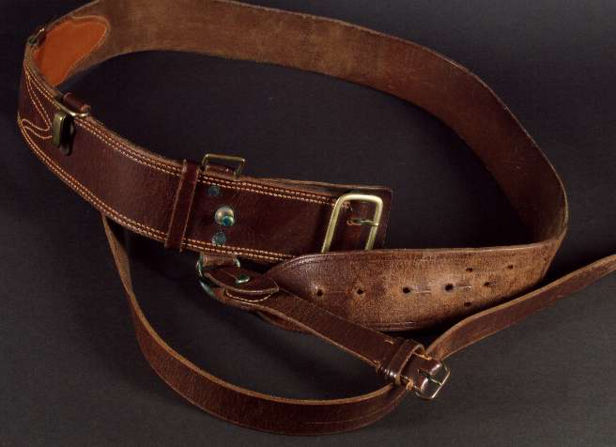 Uniform av diagonalvävt ylletyg. Guldgaloner och gradbeteckningar av gulmetall. Knappar av gulmetall med riksäpple. Fodrad med grått konstsiden. Skärp av brunt läder med axelrem. Skärp av metalltråd i guld och blått, läderfodrat, mässingsspänne. Uniformsmössa av grått kypertvävt ylle. Svart läderskärm, guldsnodd. Mässingsknapp och emaljkokard. Text: Arméns centrala beklädnadsverkstad. Skärmmössa med skärm av tyget. Båtmössa.