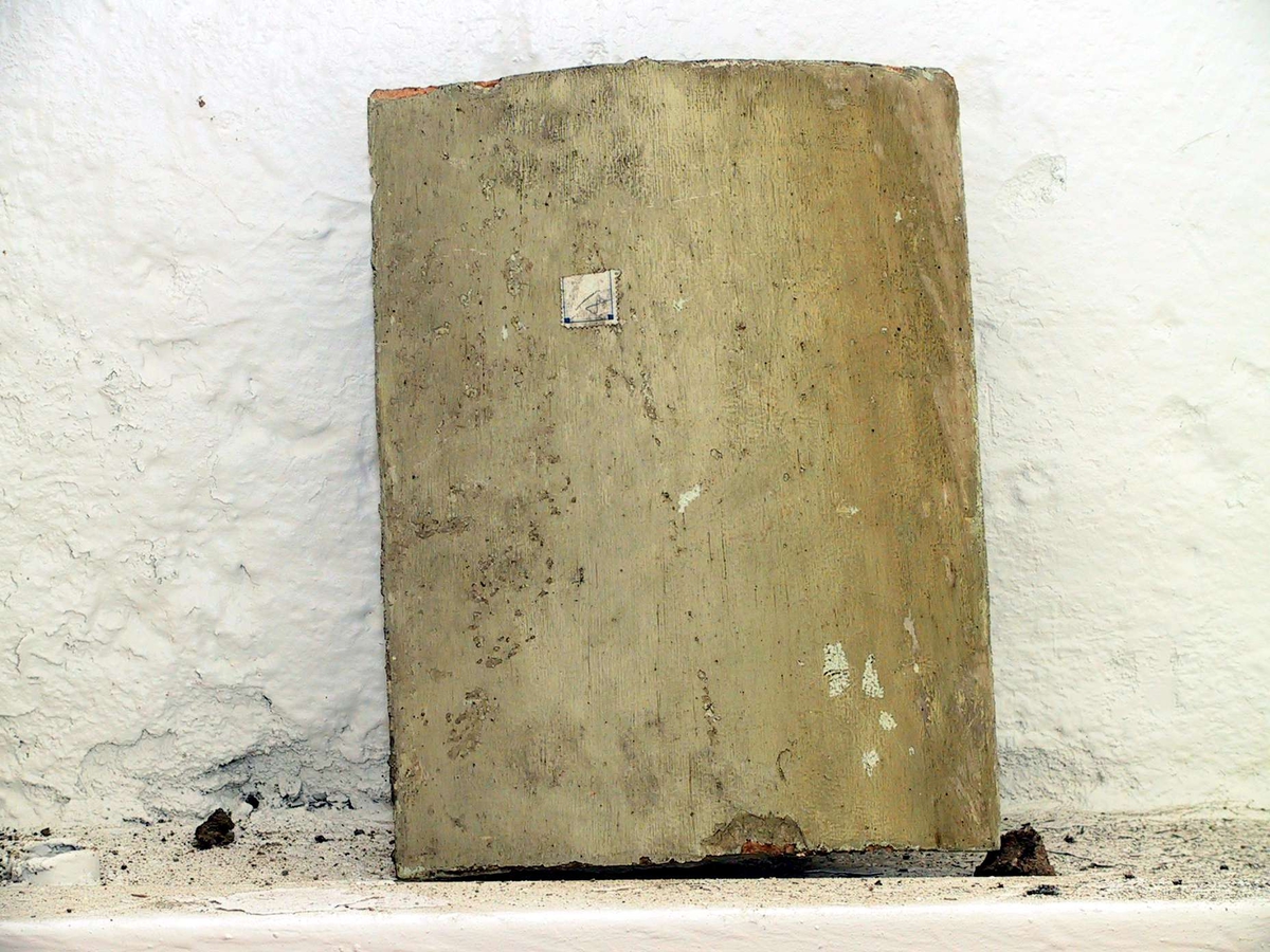 Kakel till rund kakelugn, målade med svagt gul och turkos färg. 45 hela kakel, 35 delar av kakel samt 26 delar till över- och/eller undersims. Vissa av kaklen har märkts med etikett med blå tunn ram.