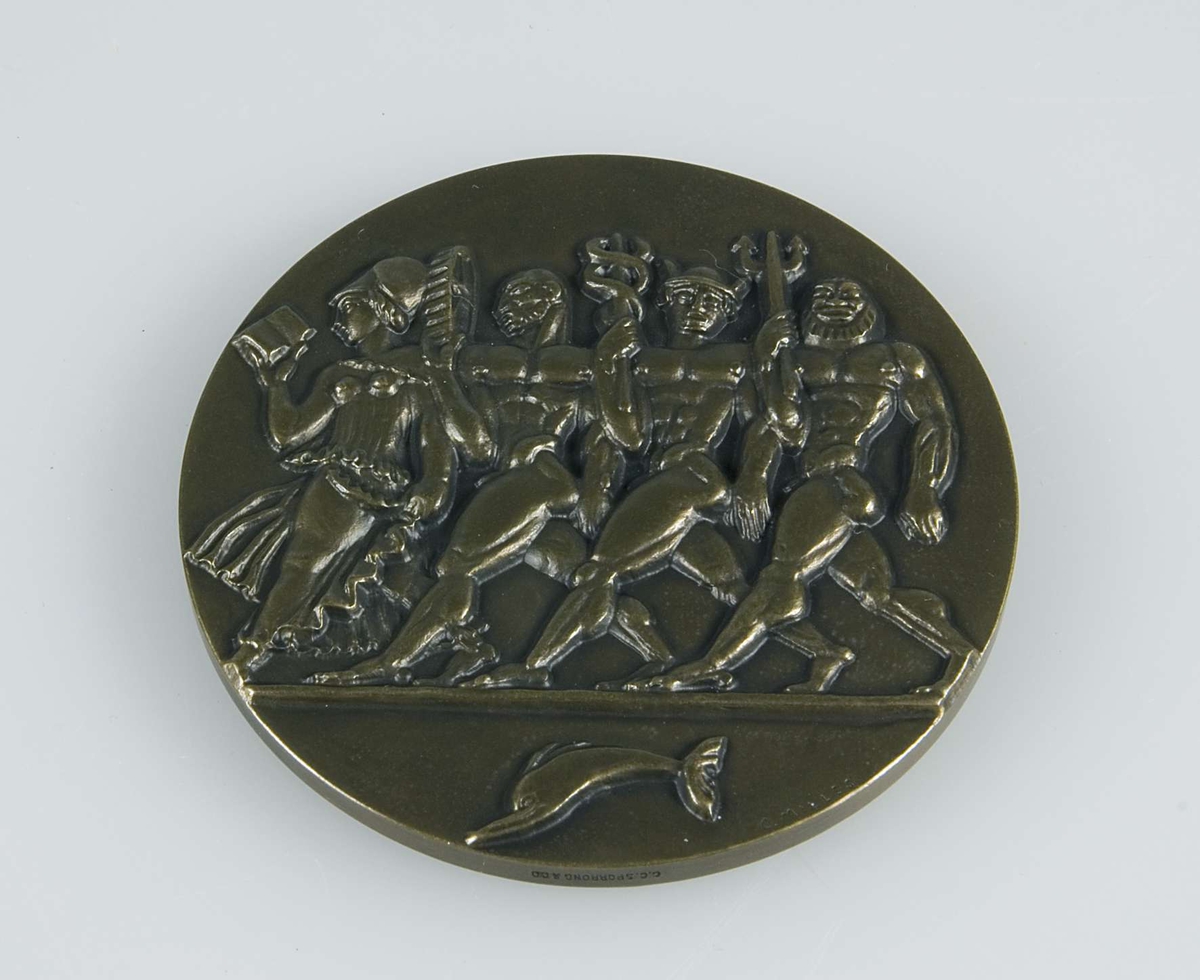Rund medalj av brons. I relief finns på framsidan texten "JUBILEUMSUTSTÄLLNINGEN GÖTEBORG 1923" samt ett lejon med svärd, krona och sköld med tre kronor. I relief på baksidan finns fyra figurer, sannolikt föreställande gudar, och en delfin. Längs kanten på baksidan står "C. MILLES" med liten text. På sidokanten står "C.C. SPORRONG & CO".