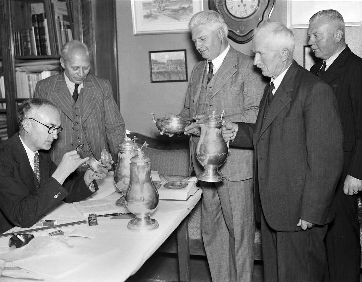 Intendent Nils Ålenius besiktigar silverföremål inför den stora utställning med äldre Uppsalasilver, som han gjorde för Uppsala Fabriks- och hantverksförening, Uppsala 1944