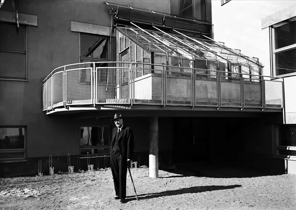 Man framför balkong med växthus, Botaniska trädgården, Uppsa